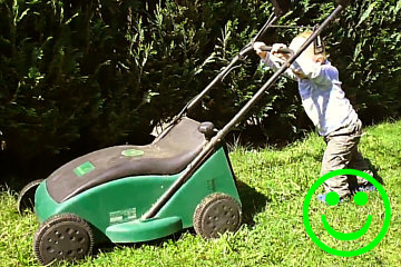 2-jähriges Kind beim Rasenmäher schieben